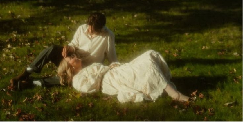 A couple sharing a quiet moment on the grass in a sunlit garden